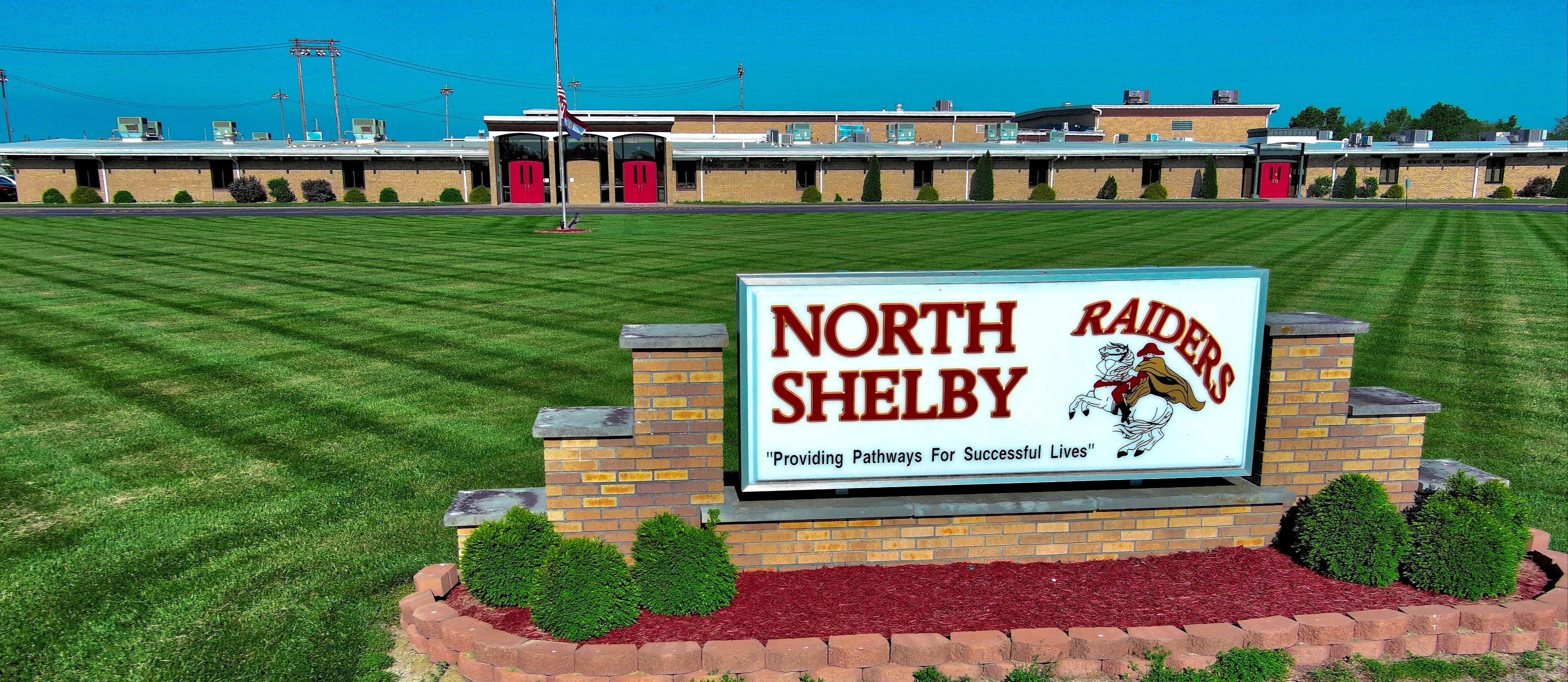 front of north shelby building with sign and fresh cut grass