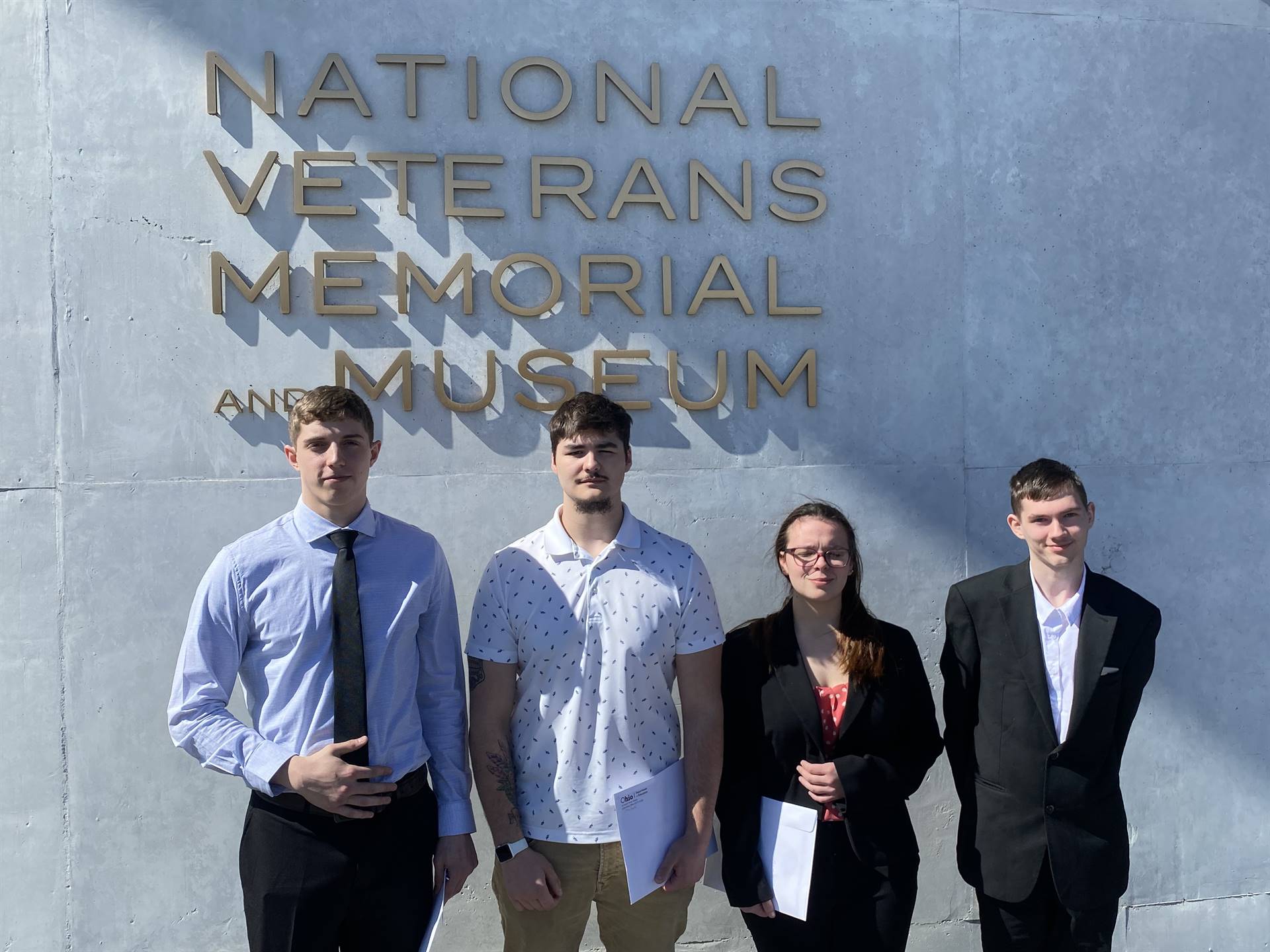 2023 enlistees posing for photo, National Veterans Memorial Museum on the background