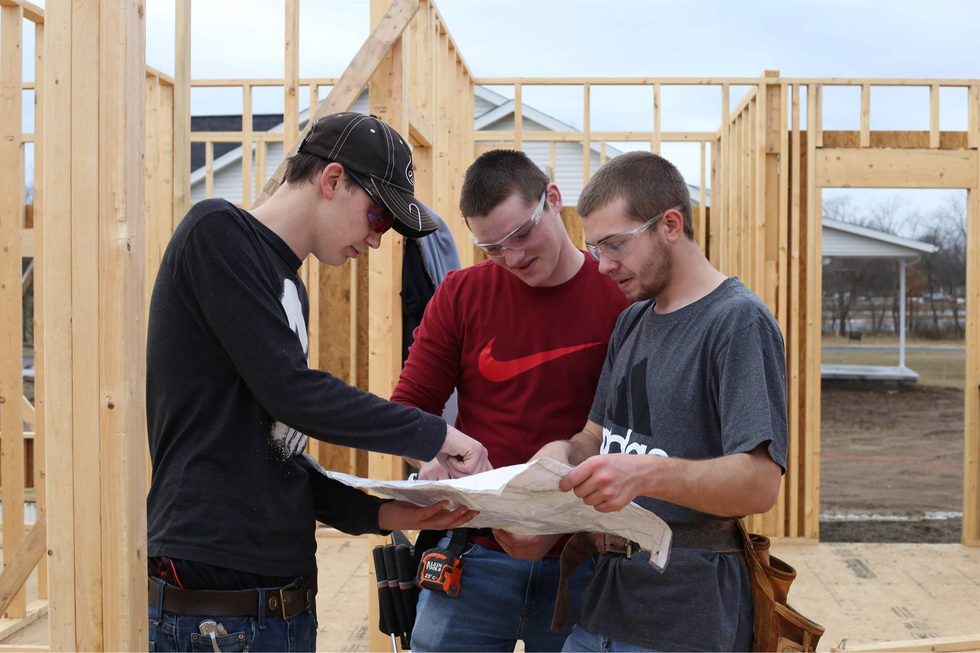 3 guys looking at a paper in a construction area