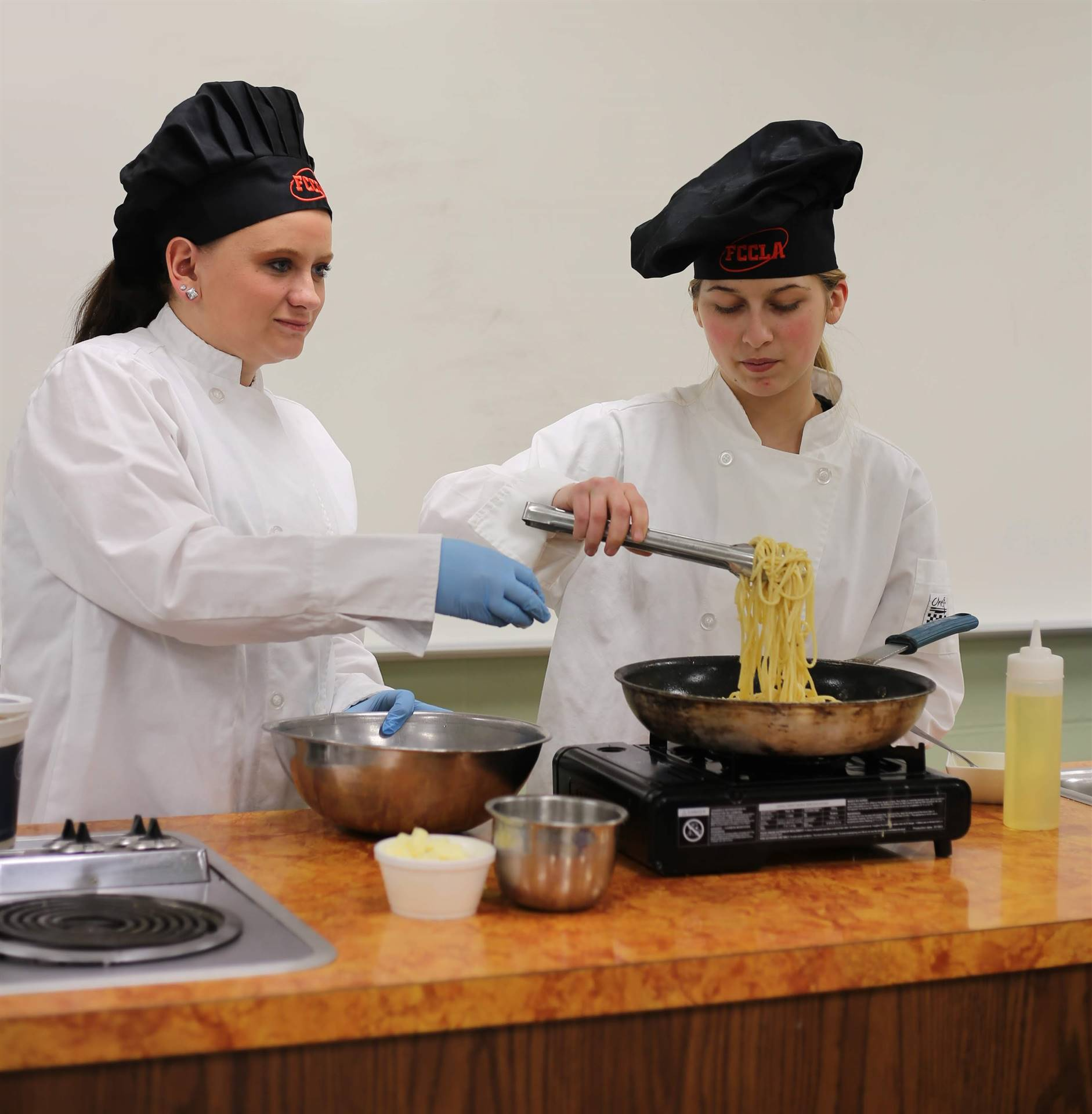 2 students cooking pasta