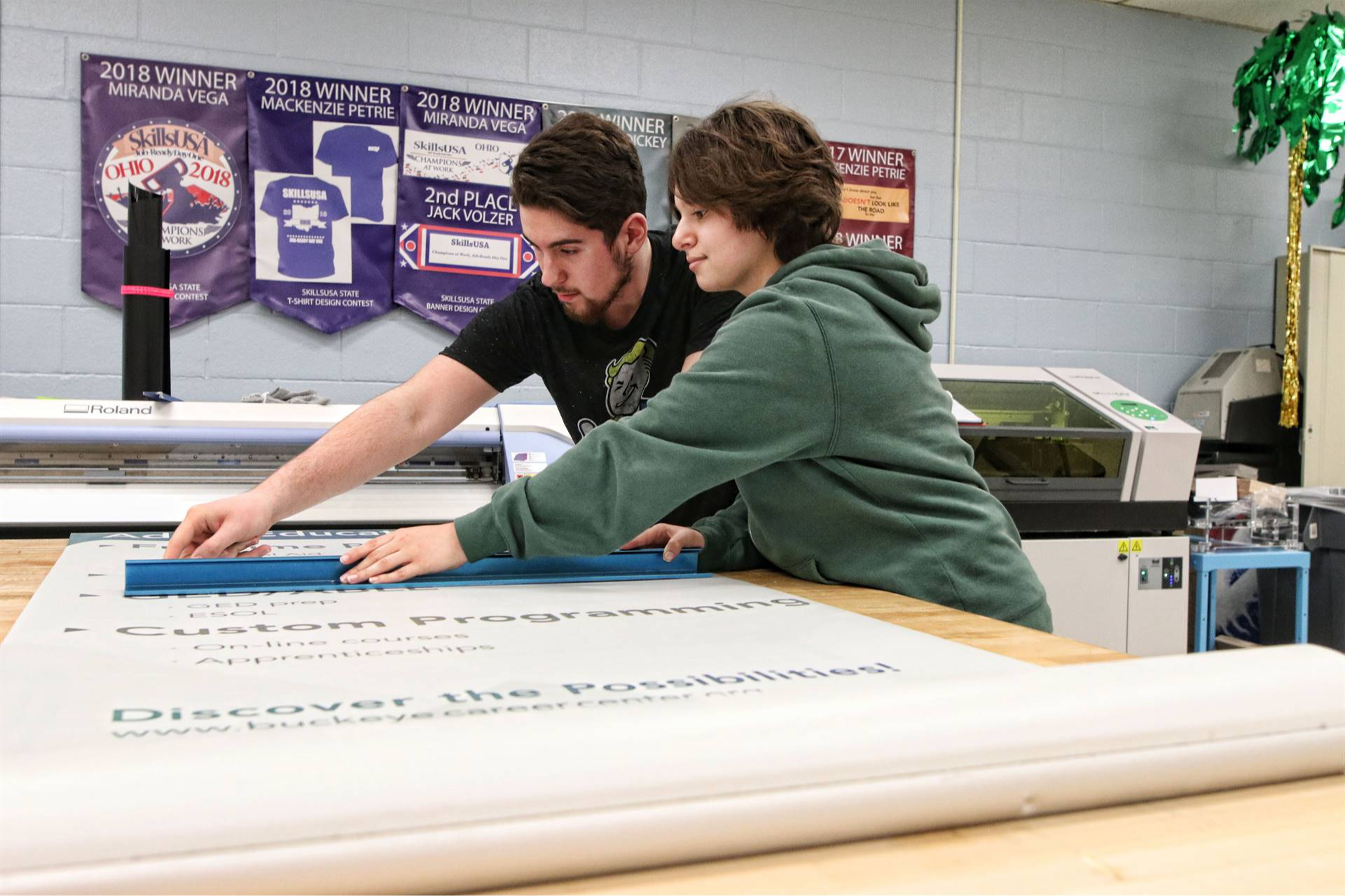 two students with a big ruler measuring some letters