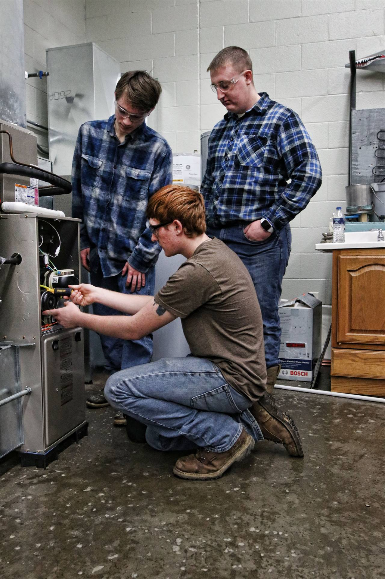 three people taking a look at some cables in a box