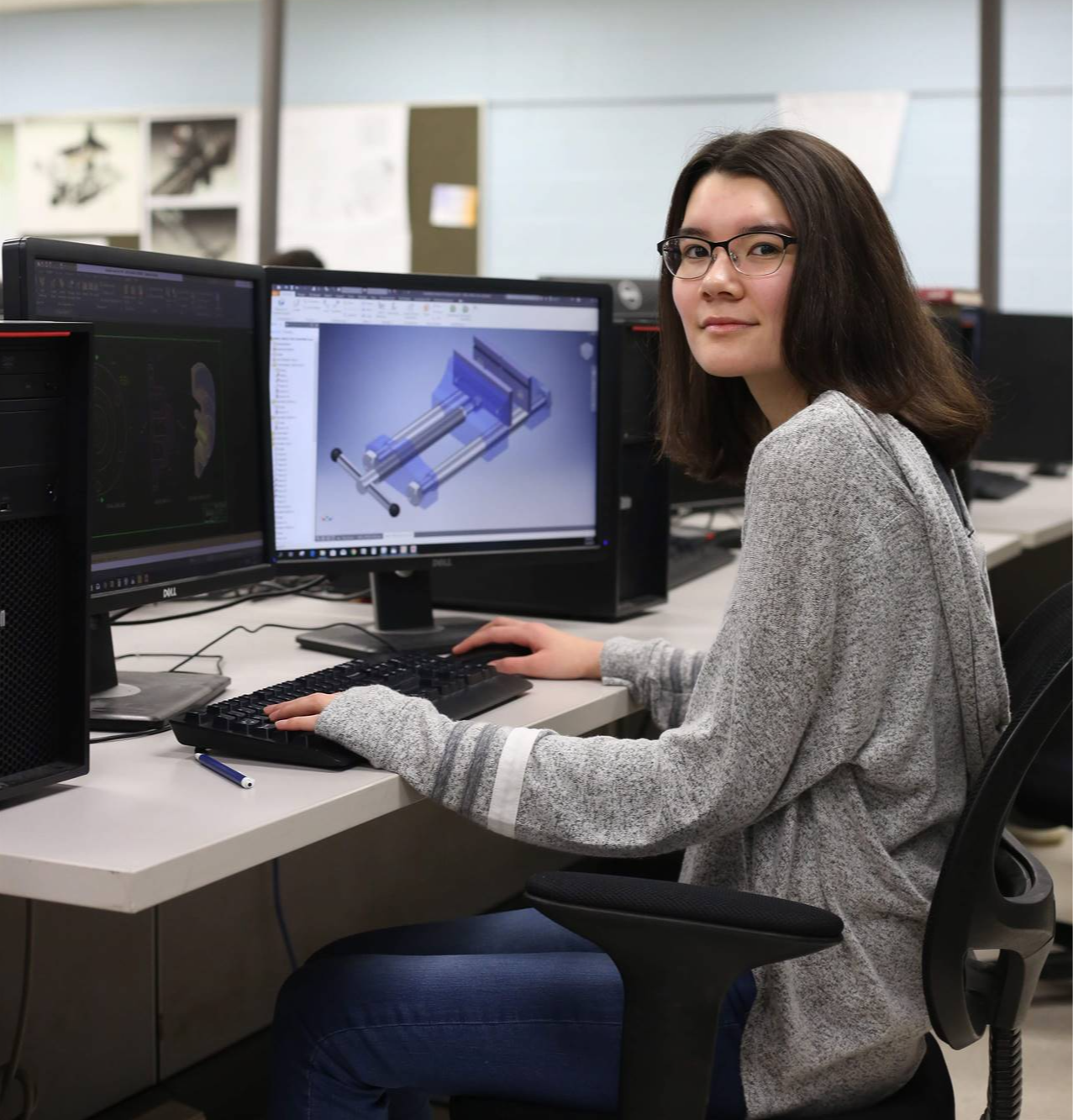 girl with glasses typing in a computer