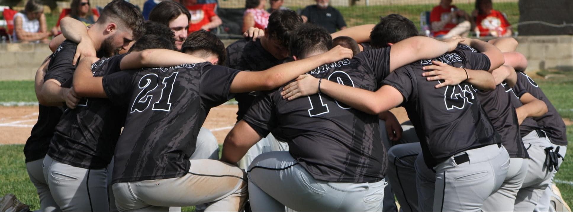 River Valley Baseball knelt down in a Huddle 