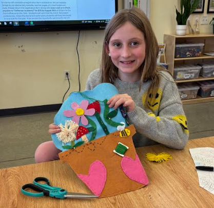 Student shows sewing progress 