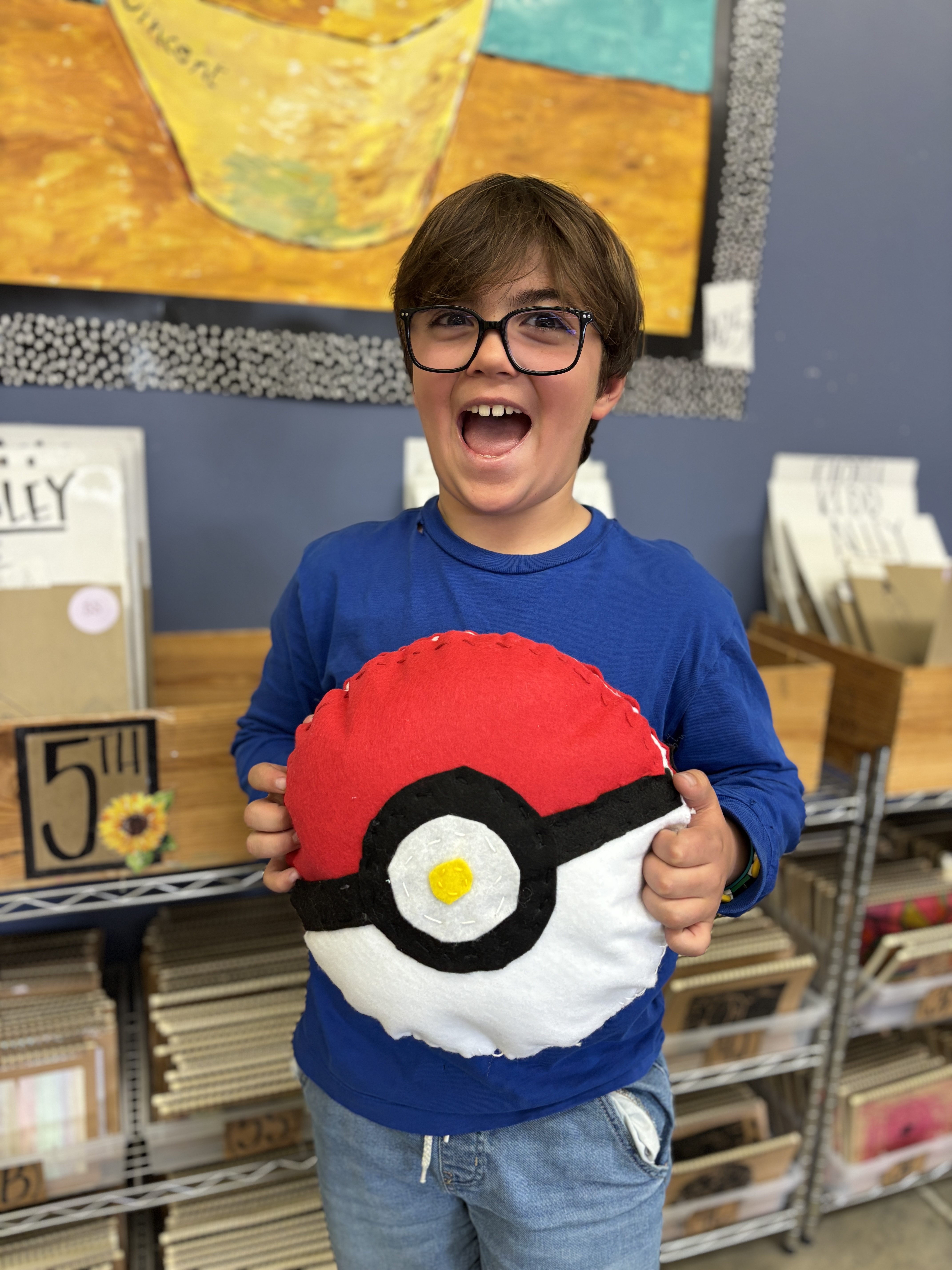 A student with his Pokemon ball stuffie creation