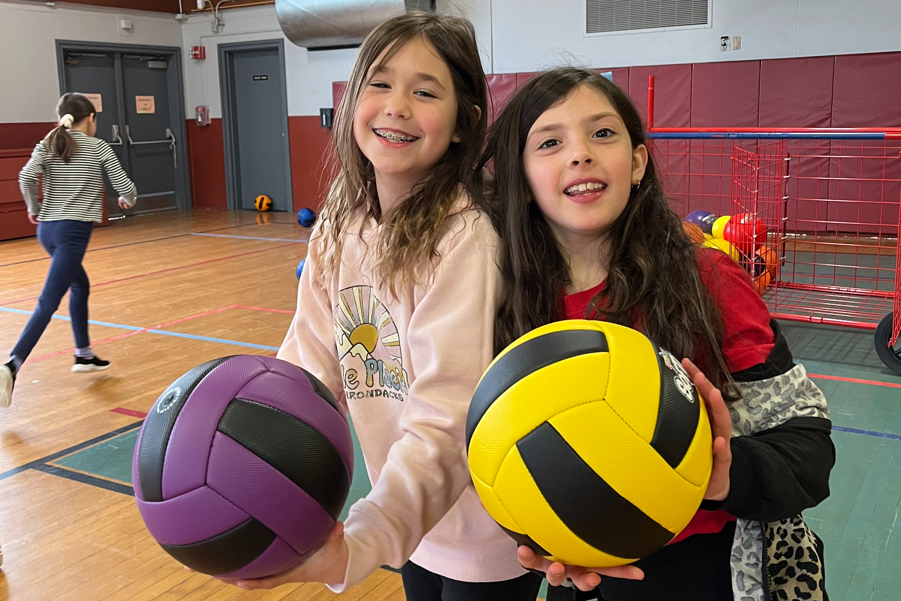 two girls with volleyballs