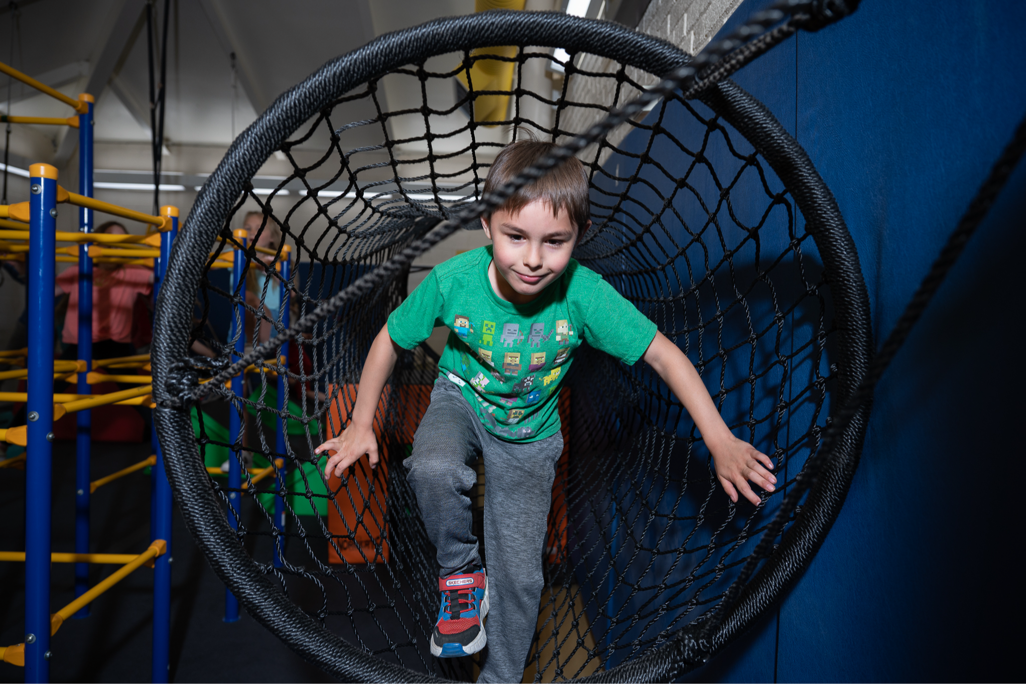 child climbing through rope net