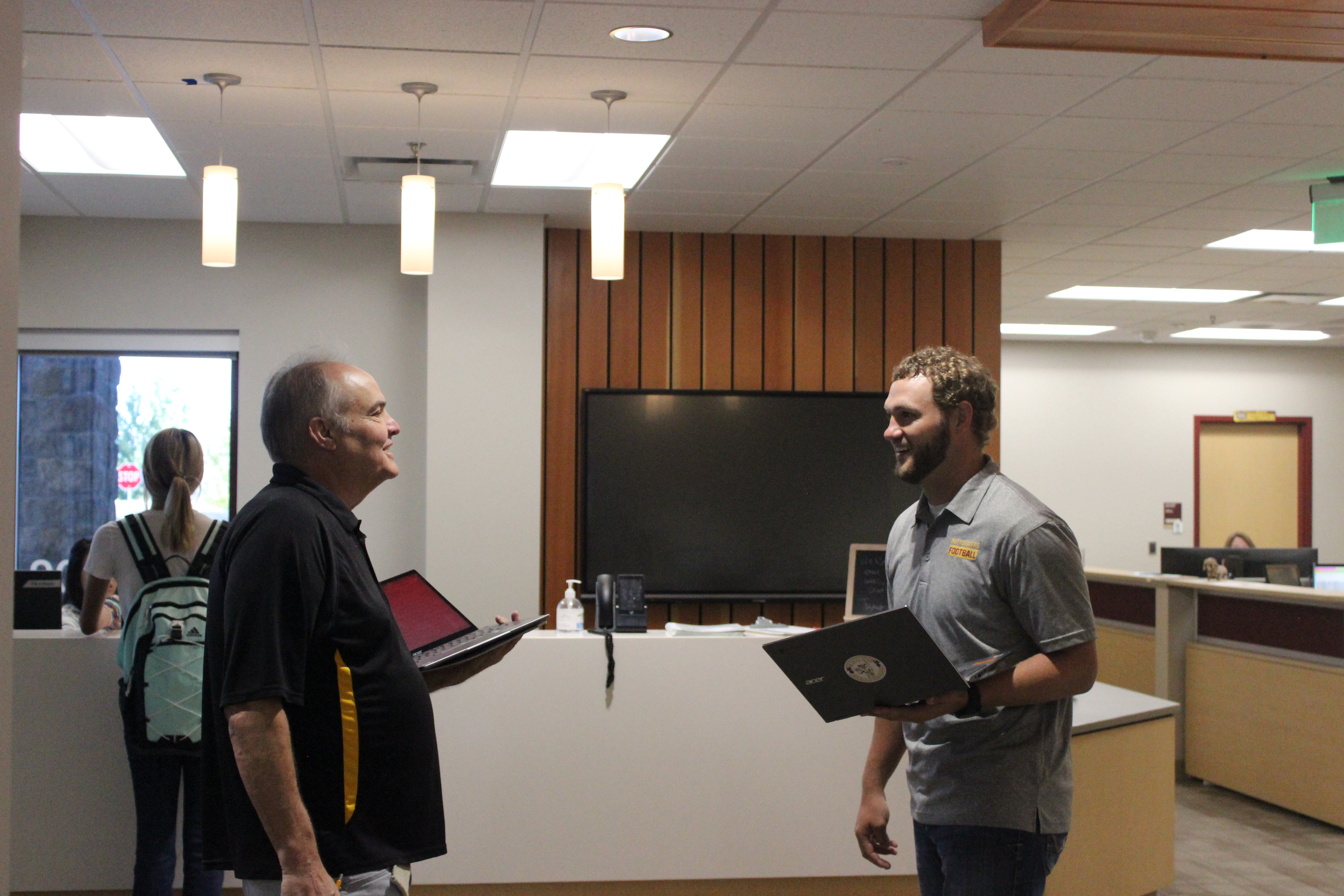 Mr. Needens and Mr. Rosenbrock conversing in the Secondary Campus office