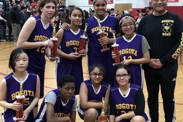 basketball players posing with a trophy