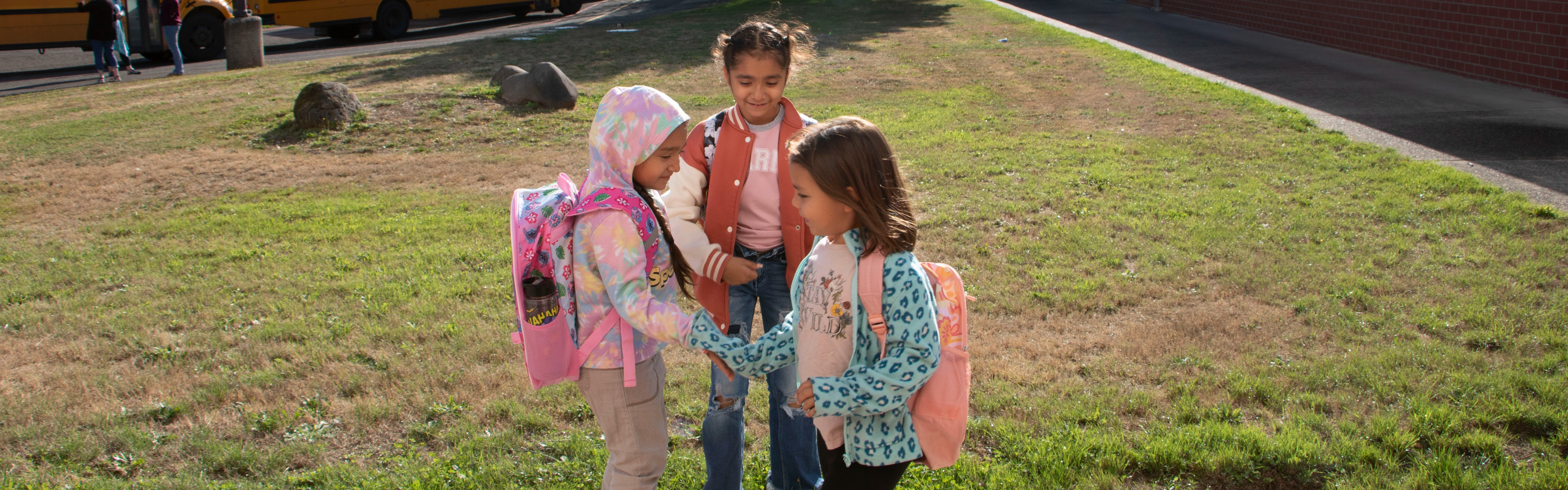 Three students greet one another on the first day of school.