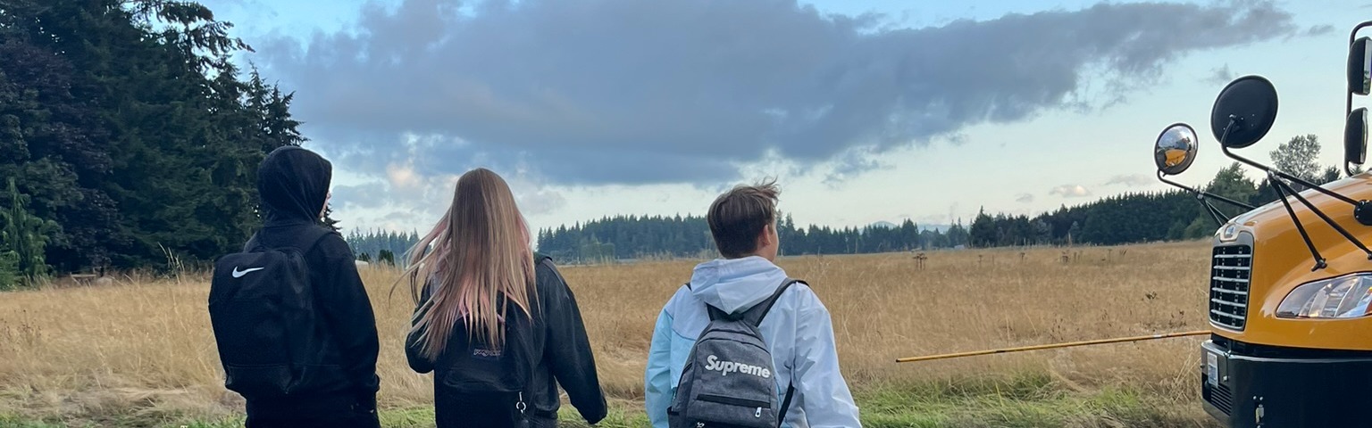 Three students walk to the bus