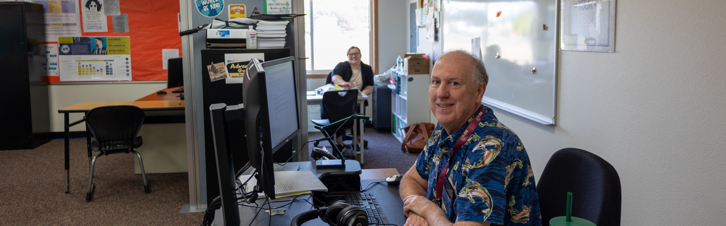 two staff members smile for the camera