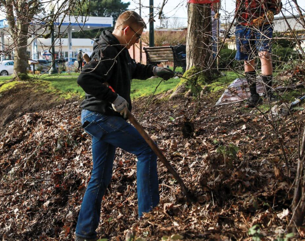 student cleaning leaves