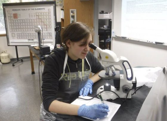 student in the lab with a microscope 