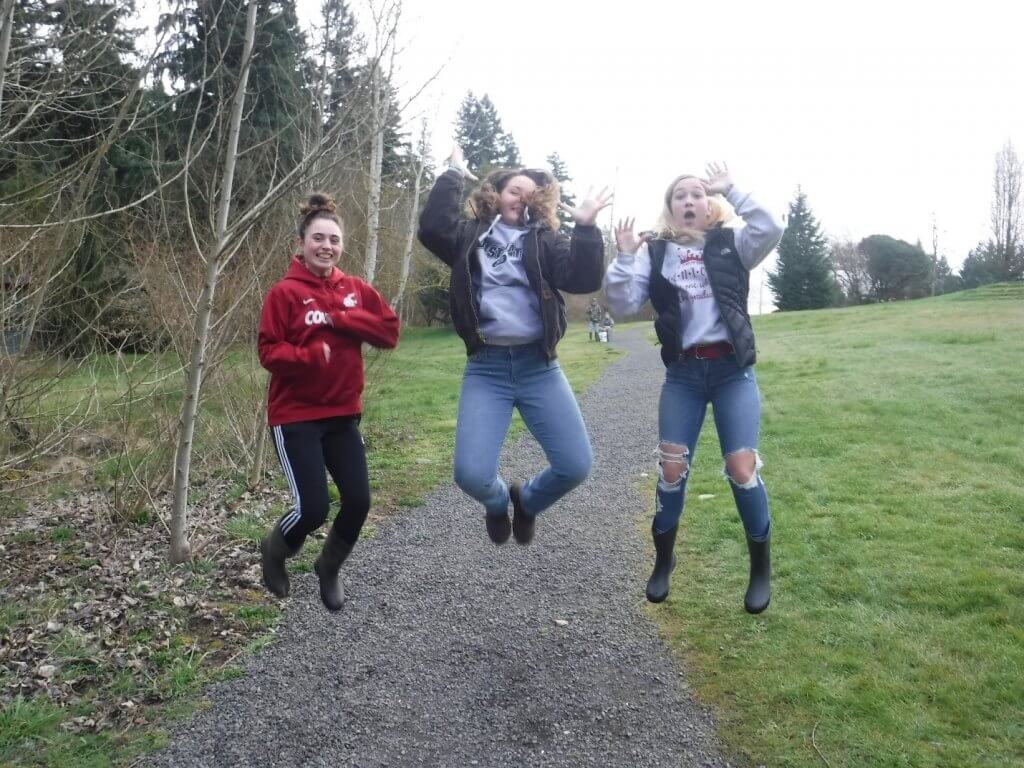 Three girls jumping in the air with joy and excitement.