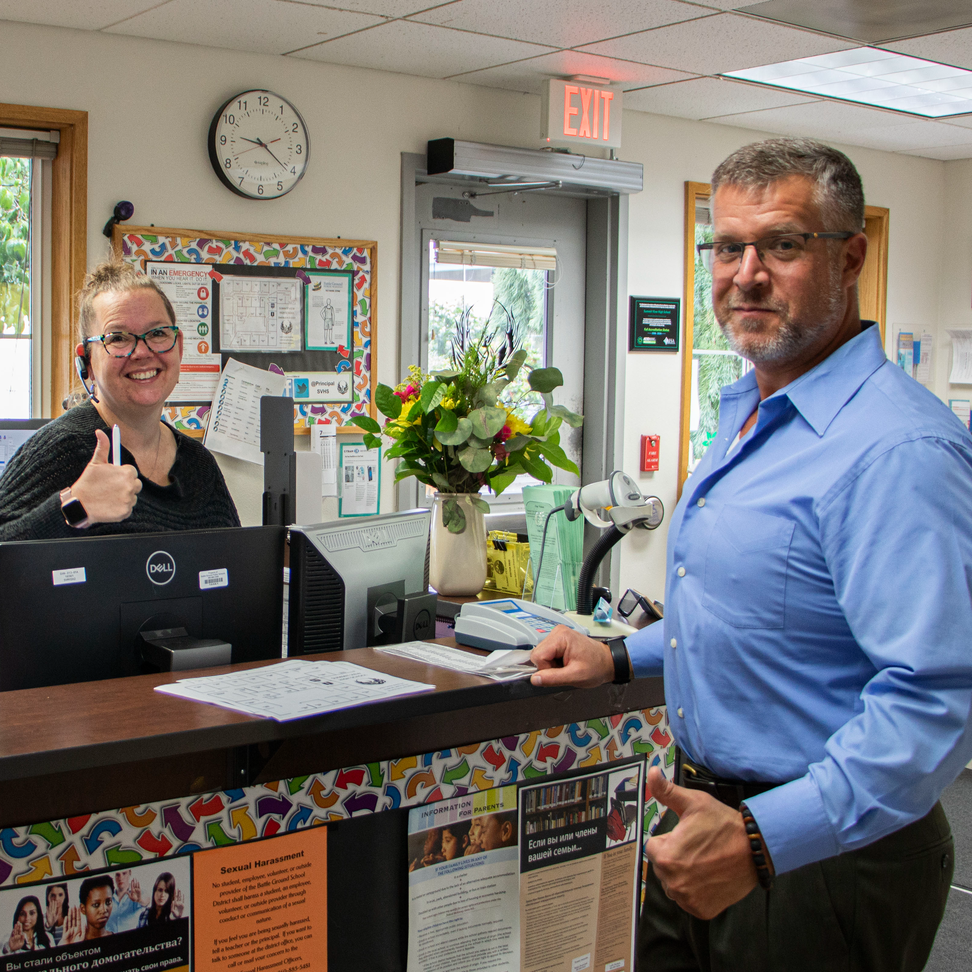 Two staff members give the thumbs up