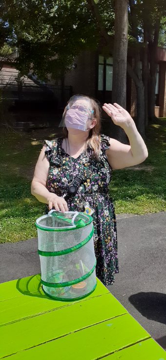 A woman in a black dress and a green bucket