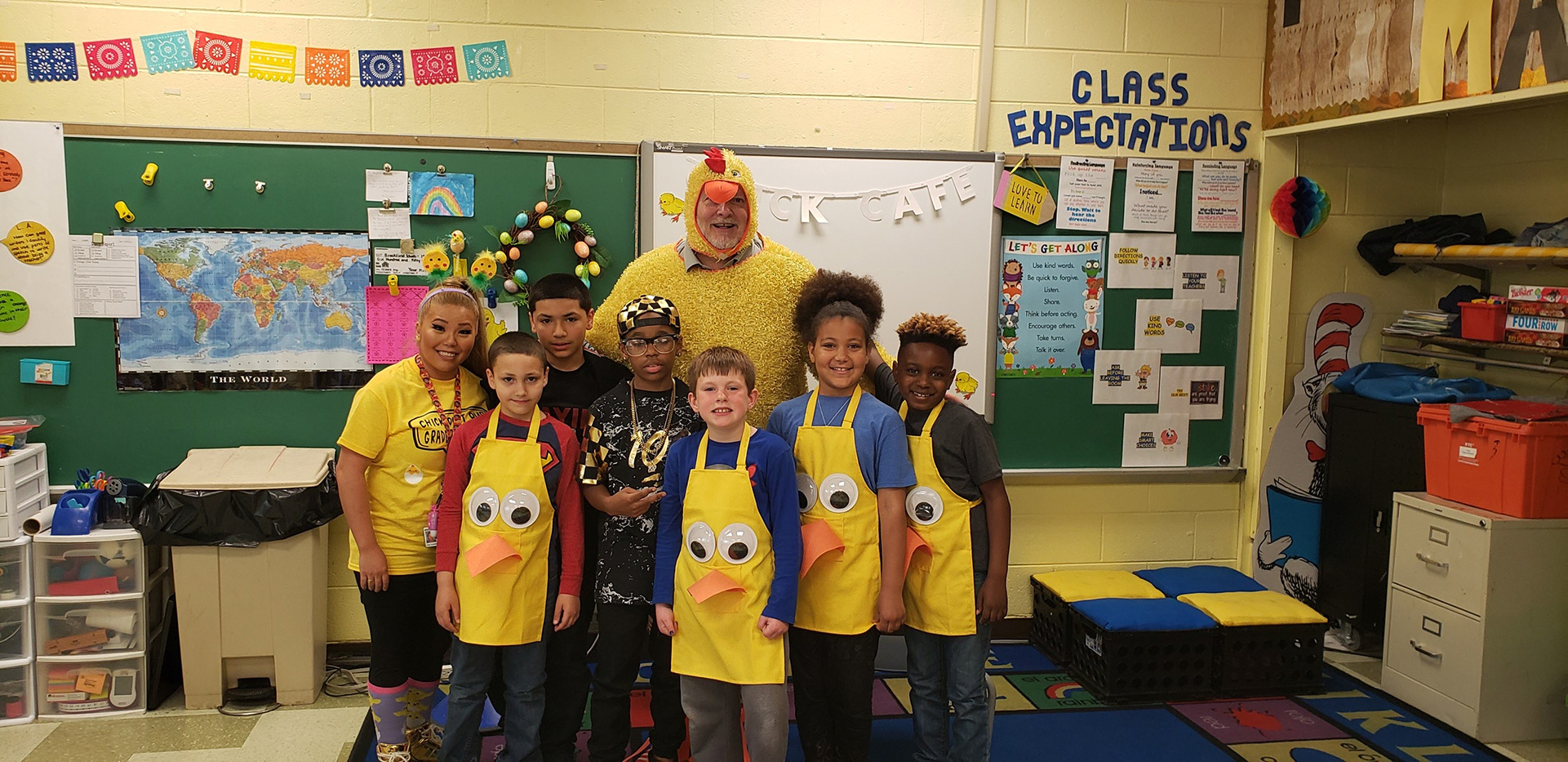 A group of children in yellow aprons posing for a picture