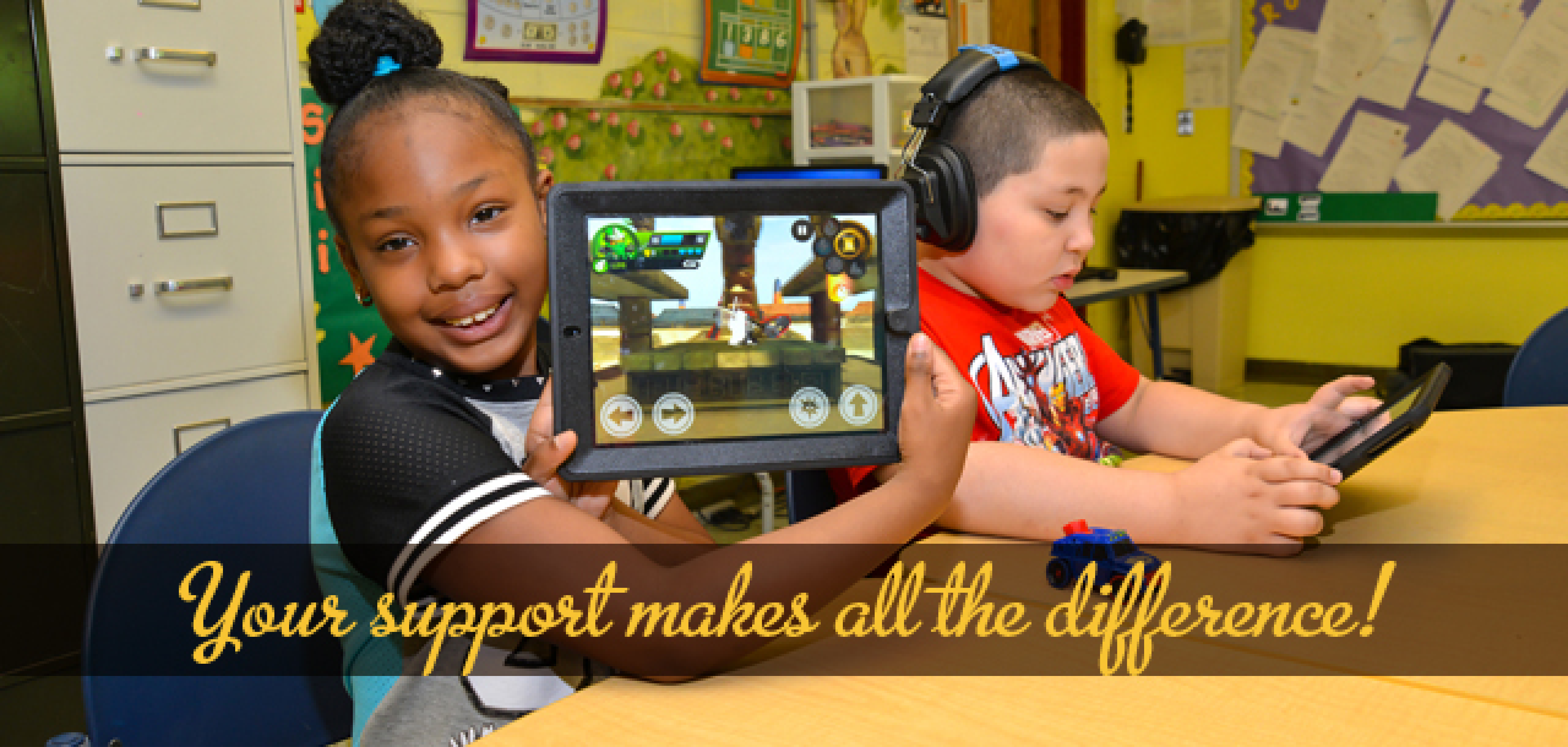 A couple of kids sitting at a table with headphones
