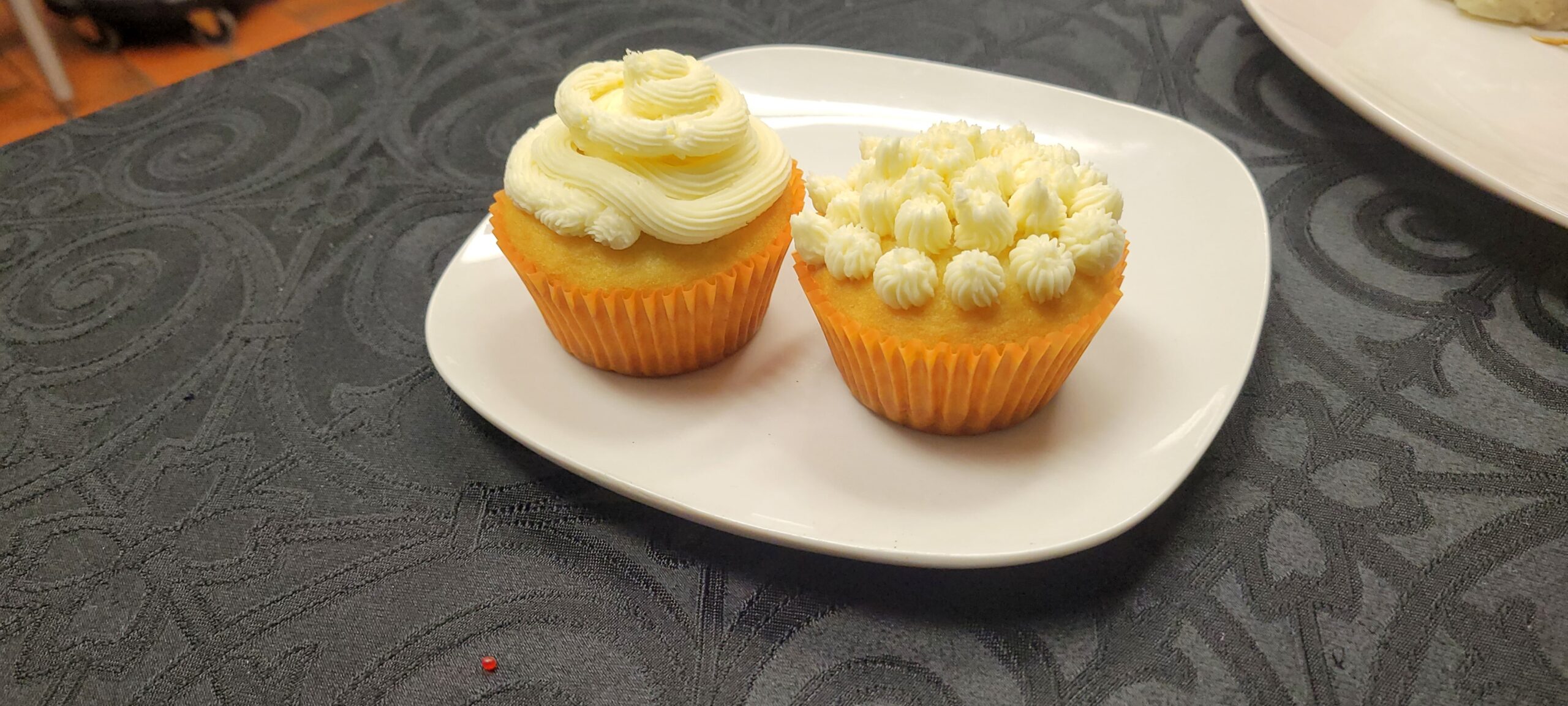 Two frosted cupcakes on a plate