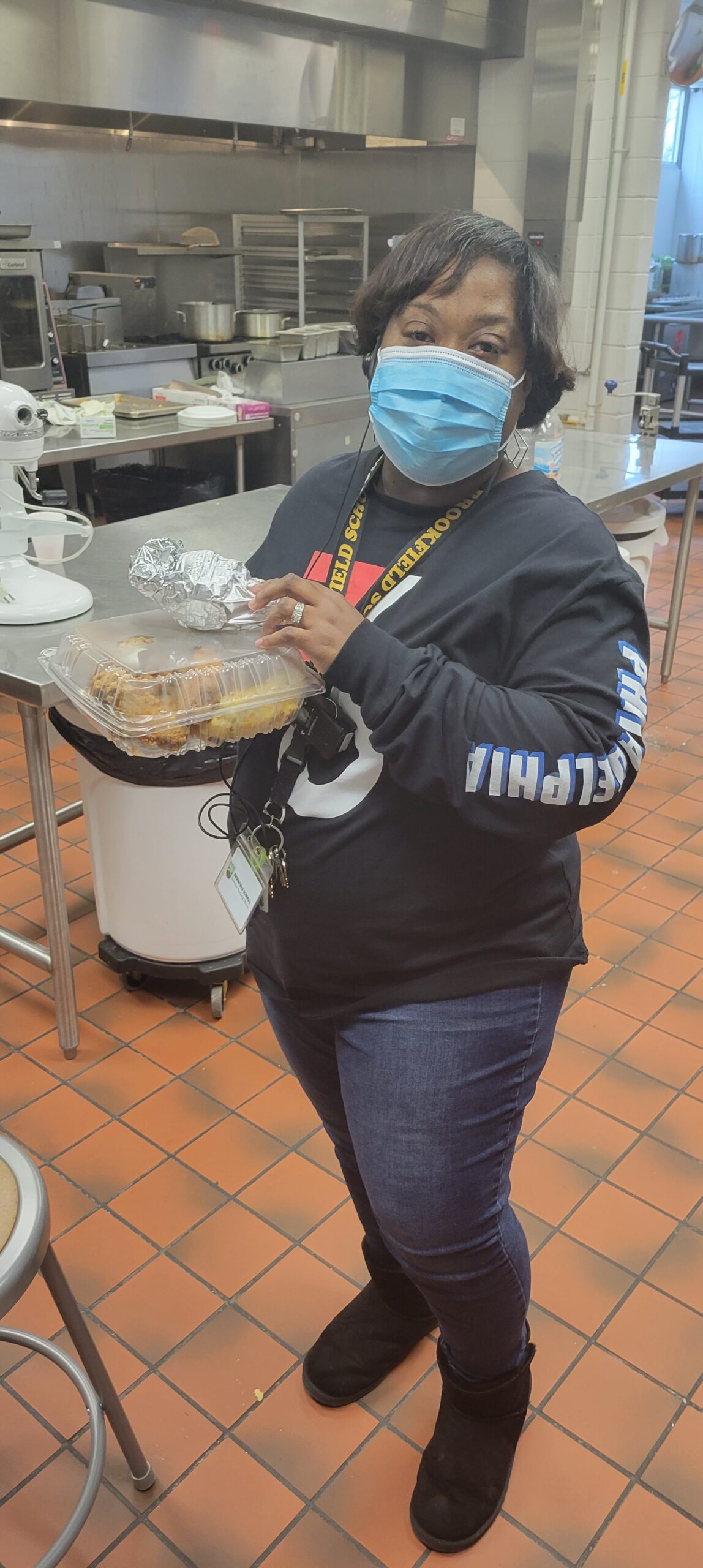 Female with mask carrying tray of food.