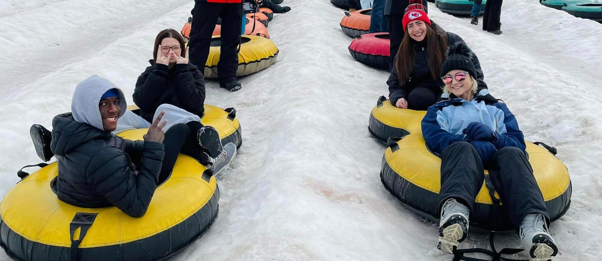 Students sitting in their snow tubes before hitting the slopes