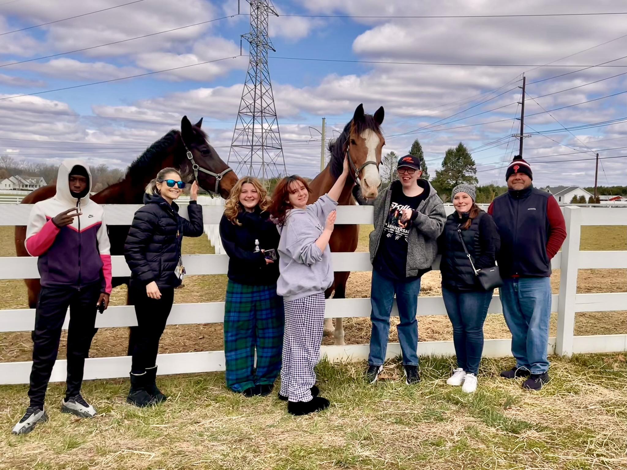 students and staff pose for picture with horses
