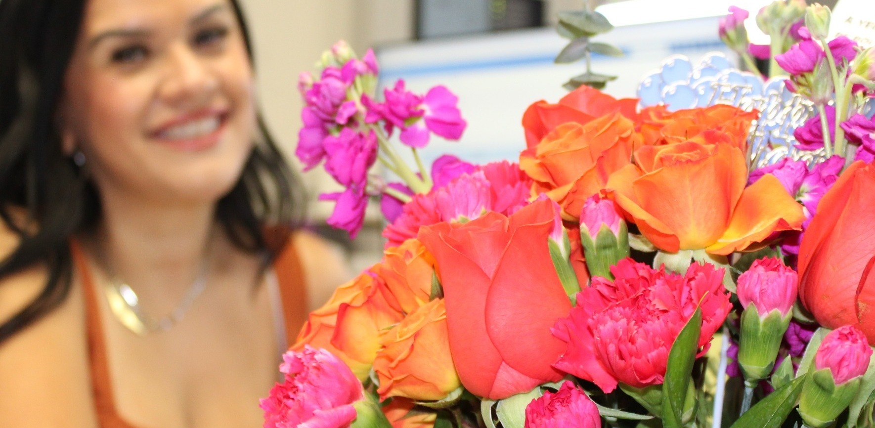 Registrar at her desk with brightly colored flowers