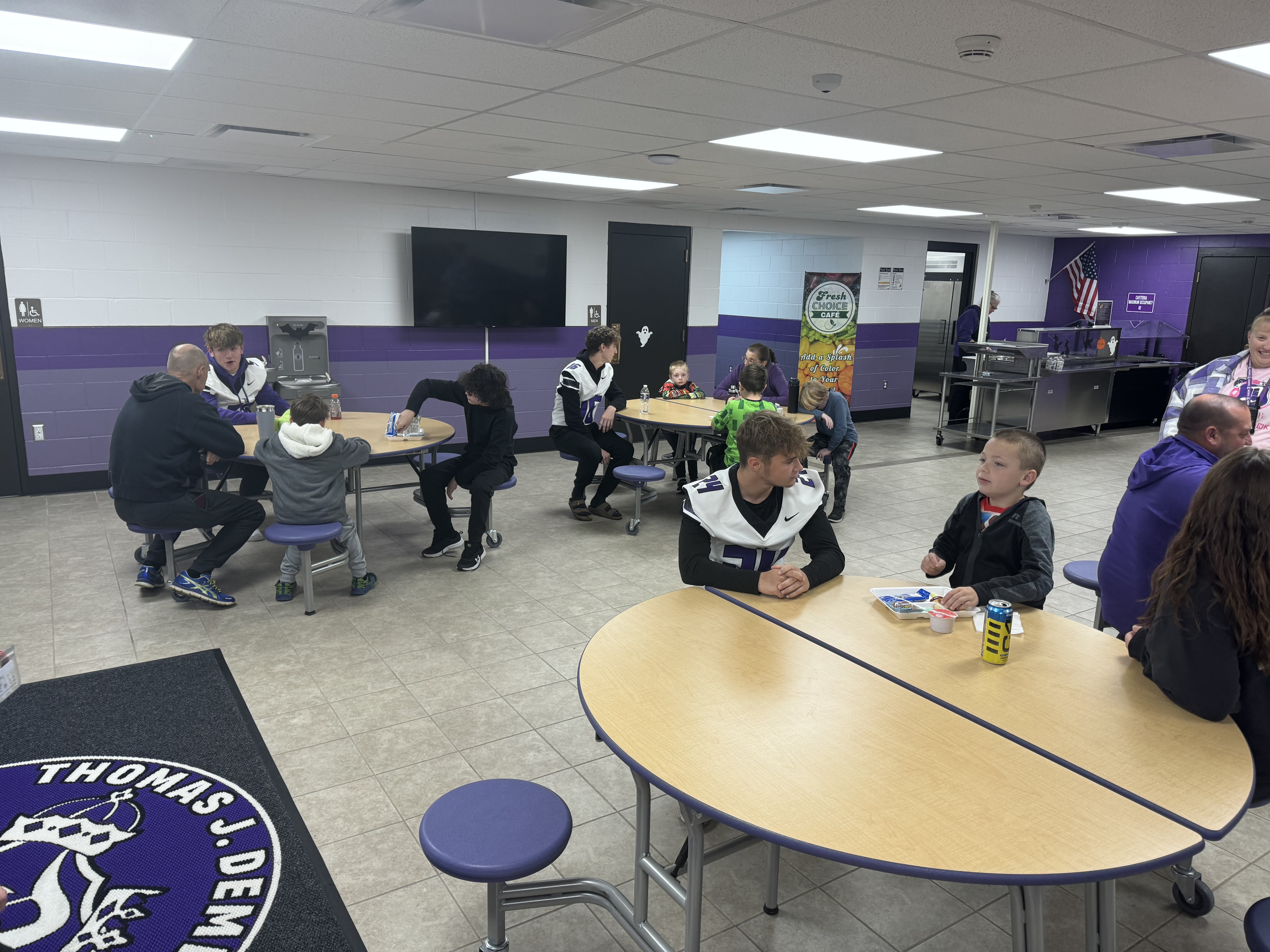 students sitting with members from football team