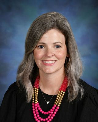 Principal Jennifer Hyde standing infront of the school entrance