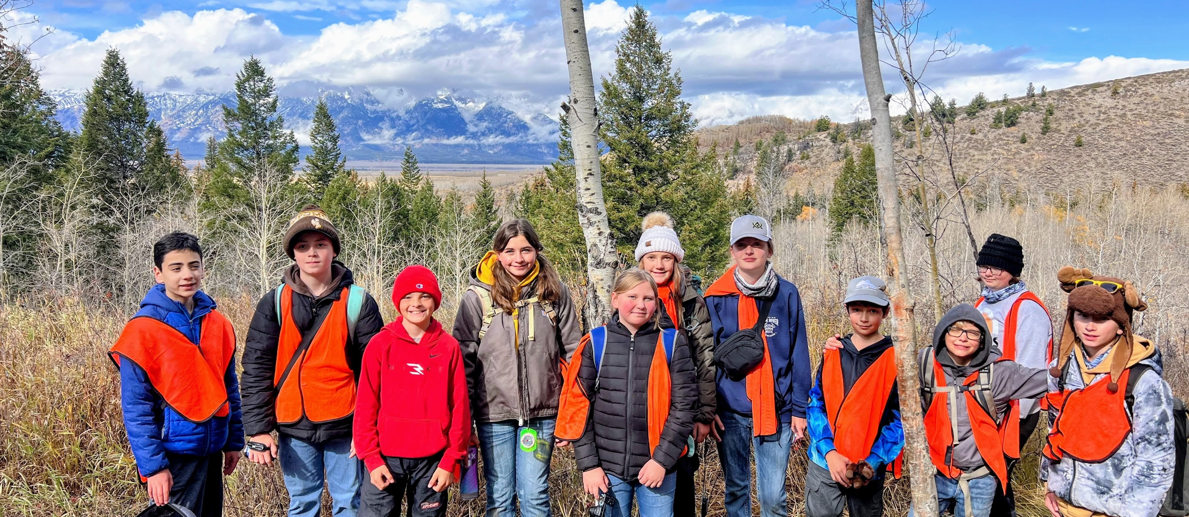 Students posing in front of mountains after attending teton science school