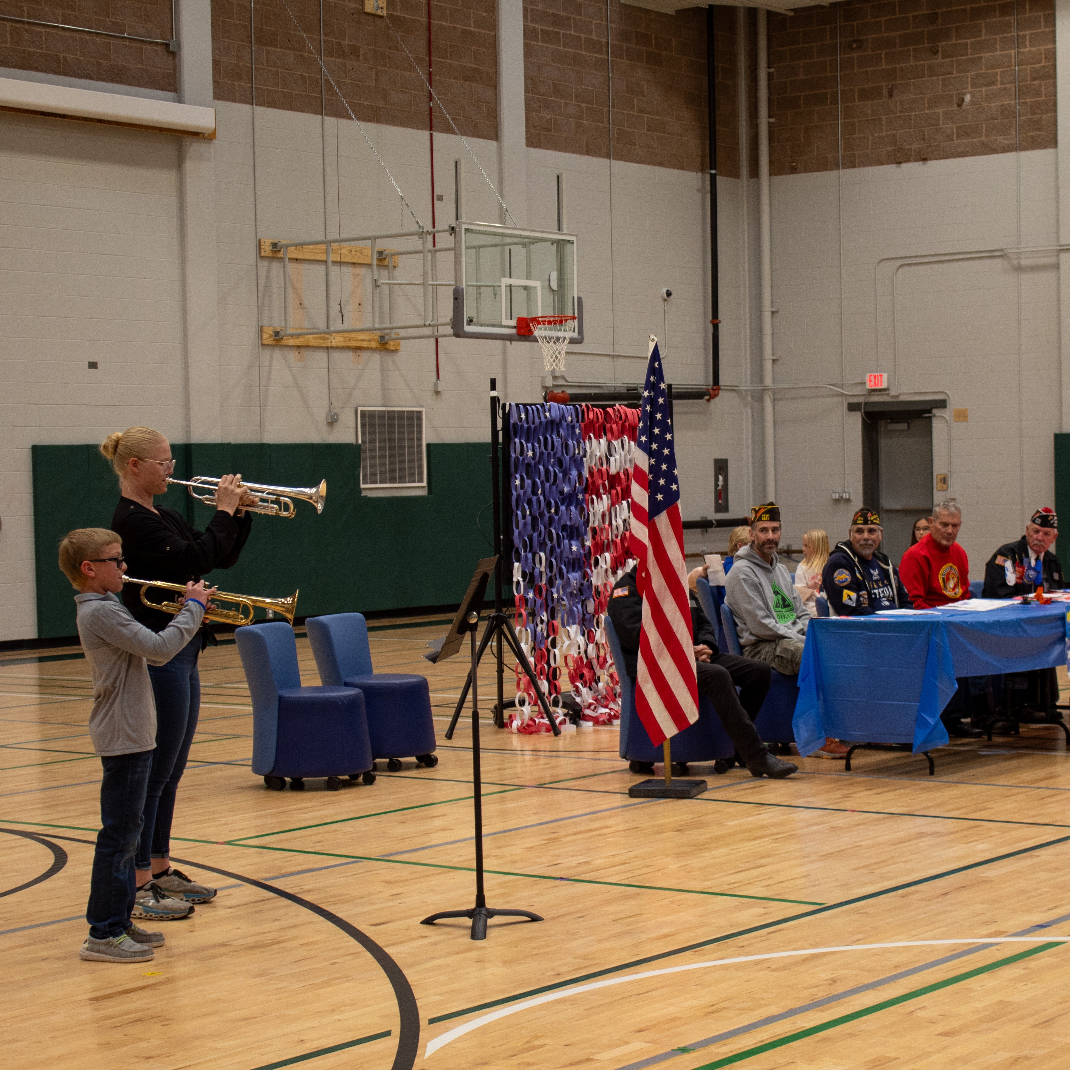 Student and mentor playing trumpet for local veterans 
