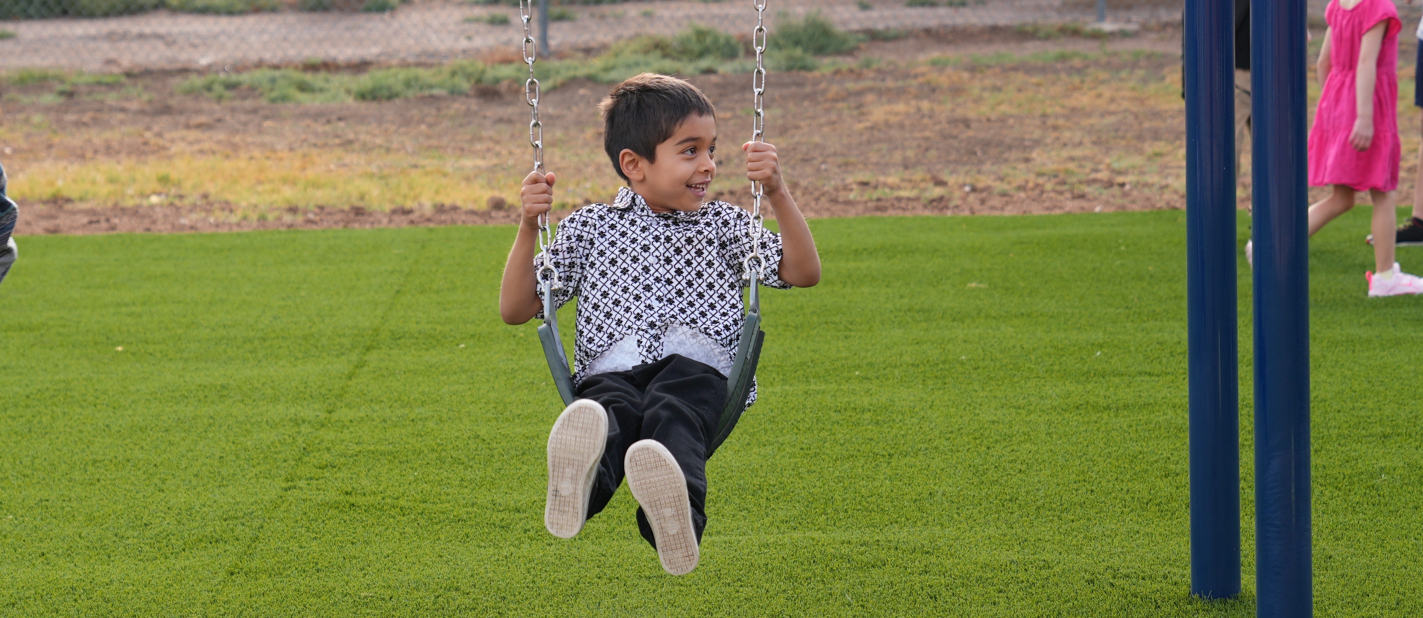 Young boy swinging on swing