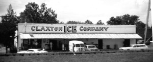 A vintage black and white photo of a store with several cars parked in front, capturing a nostalgic scene.