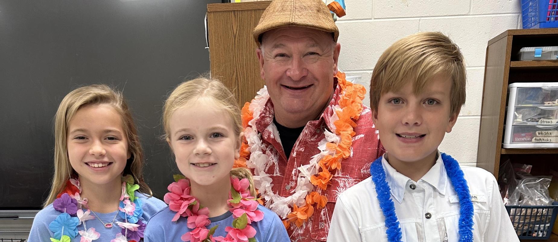 students and a staff member with leis on 