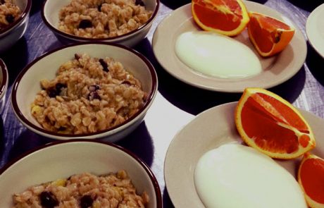 Bowls of oatmeal topped with sliced oranges and creamy yogurt.