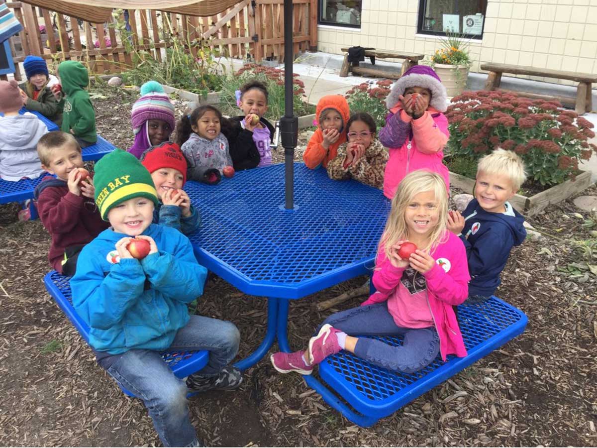 A group of children sitting around a blue table