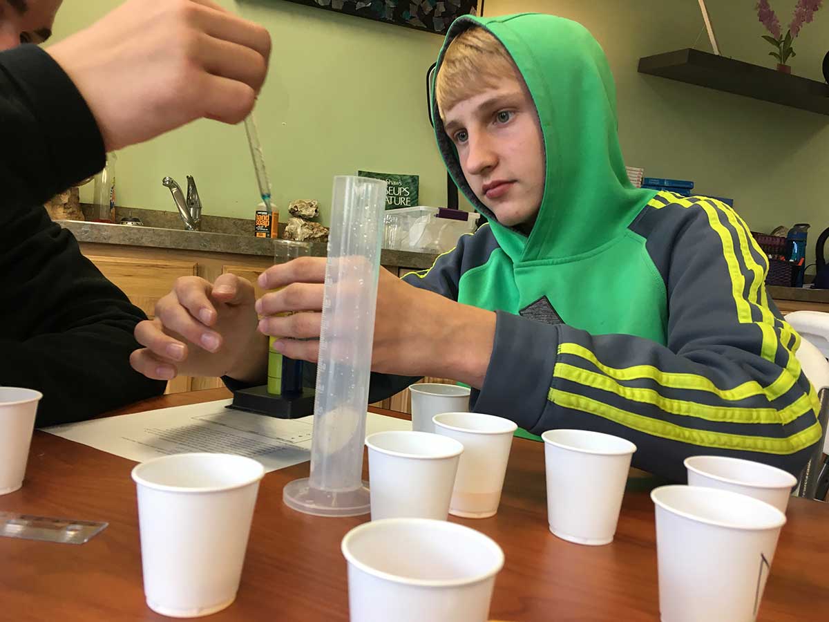Two boys collaborating on a project at a table.