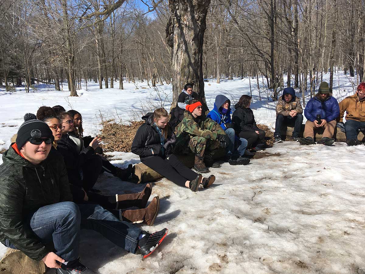 A group of people sitting on the snowy ground.