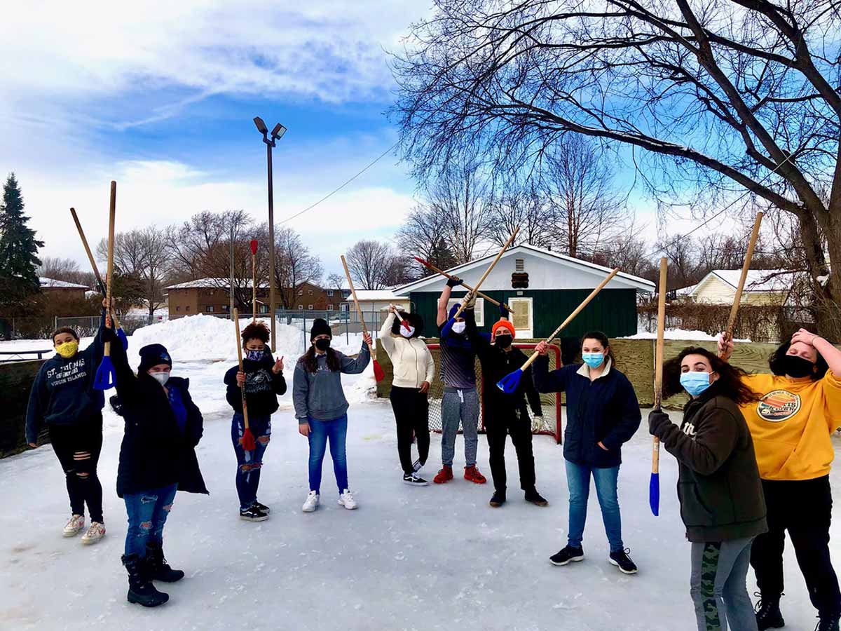 A group of people wearing face masks and holding sticks.