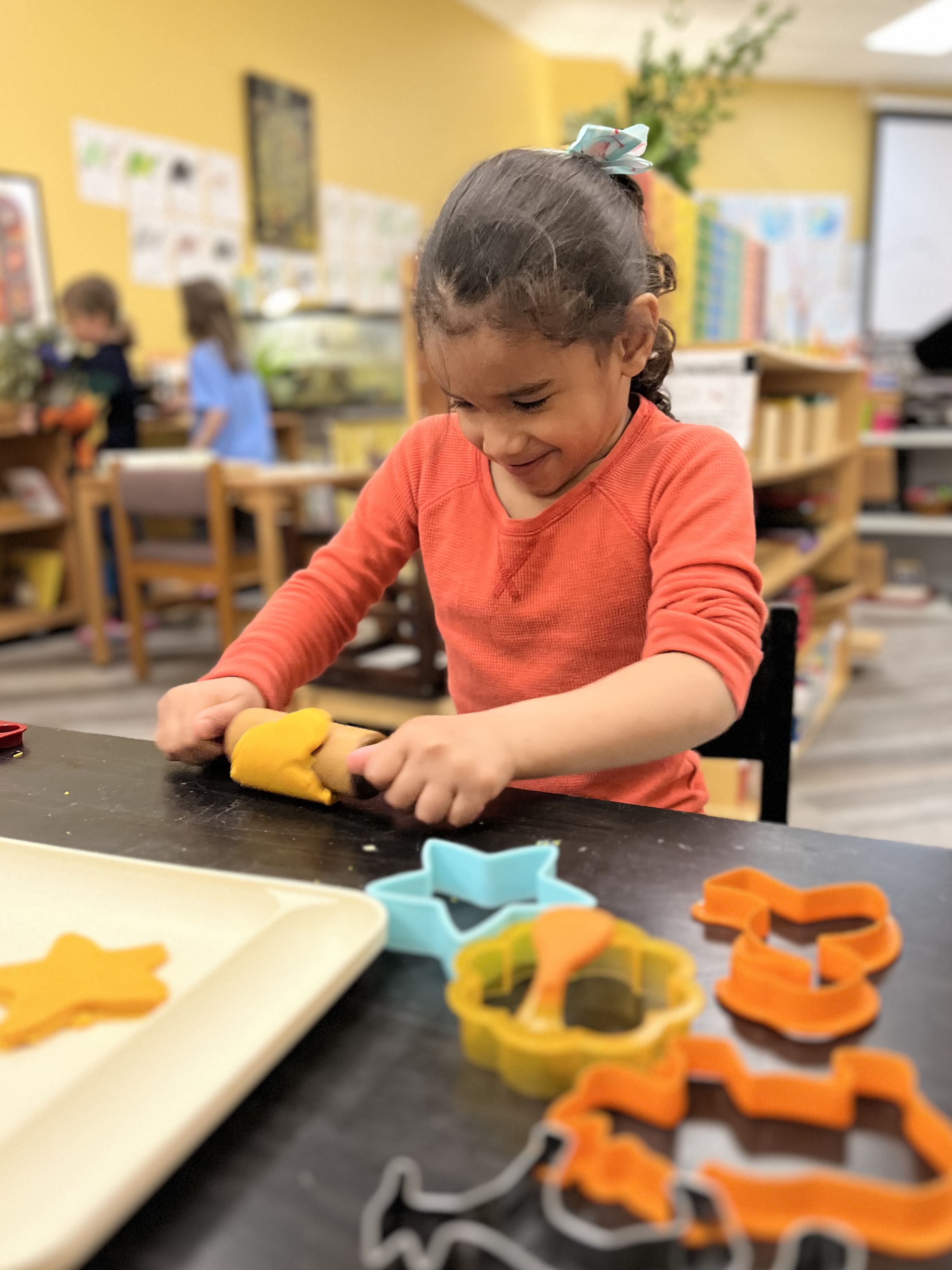 Children's House student working with play-doh.