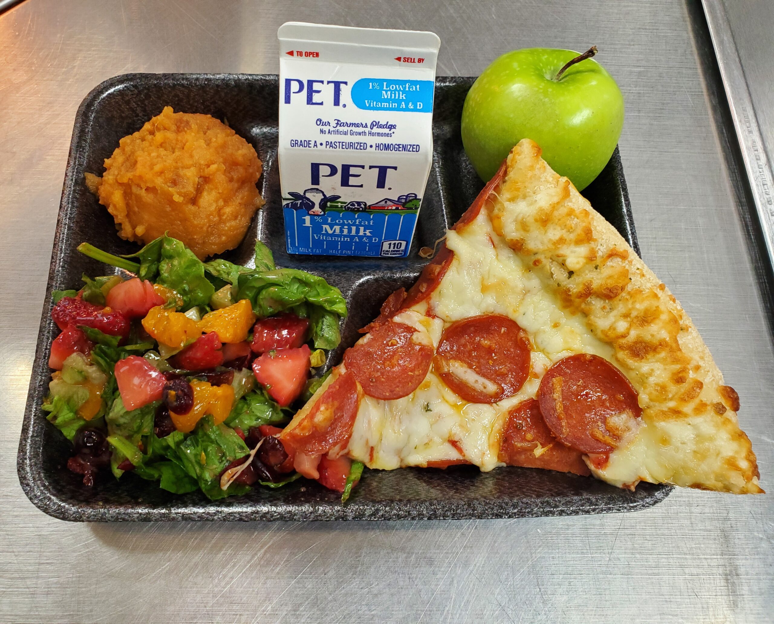 A metal tray topped with different types of food