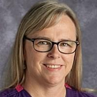 A woman with glasses and a purple shirt.