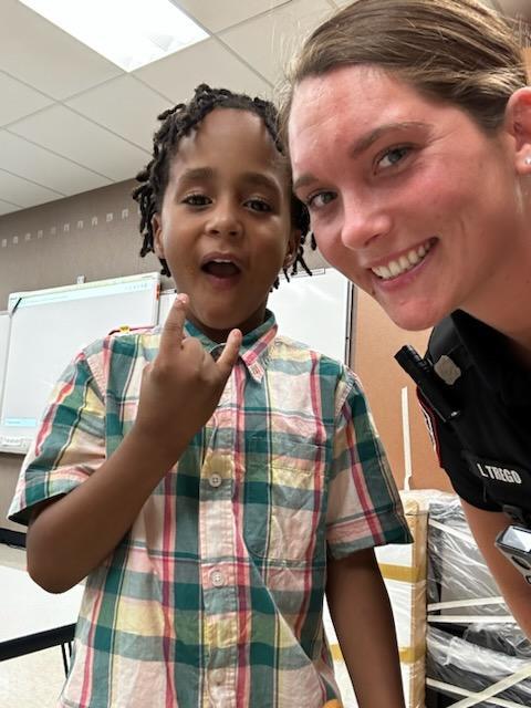 A smiling police woman with a young boy