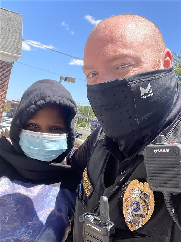 A police officer standing next to a woman in a face mask.