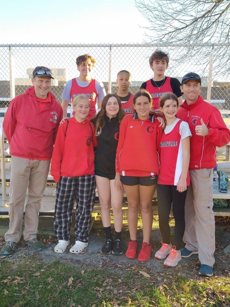 People in red shirts and black pants standing together.