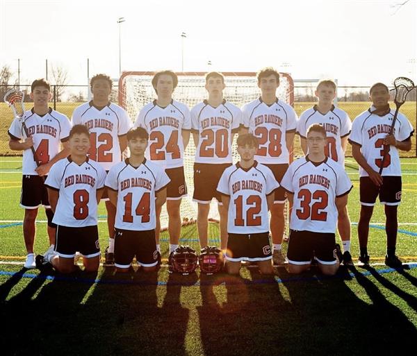 Group of male lacrosse players smiling for team photo.