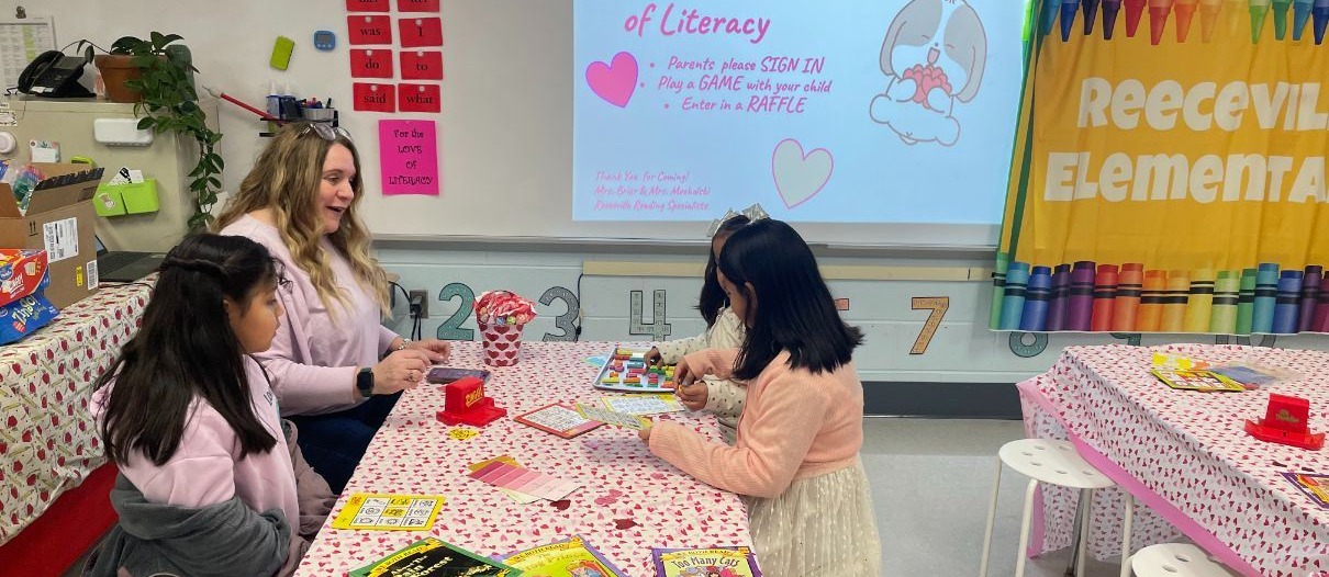 elementary students putting together valentines at a table