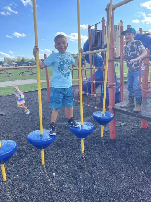 kid in the playground smiling at the camera